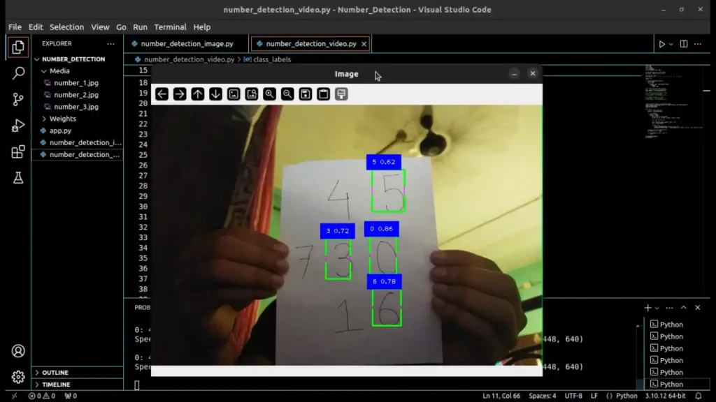 Person holding a white page with multiple numbers, detected and recognized by a Python program; code editor open in the background.